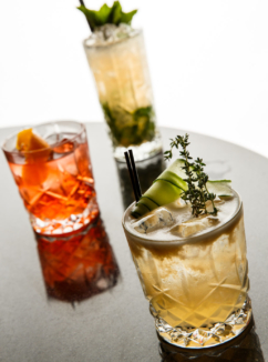 cocktails with cucumber garnish on a bar table