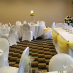 An event suite at Mercure Sheffield Parkway Hotel set up for a wedding breakfast, yellow ribbons