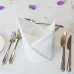 Folded napkin detail, wedding breakfast table place setting, silver cutlery
